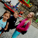 Tři děvčata stojící před atrakcemi na Chrudimské pouti.