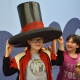 Chlapec s velkým černým kloboukem na hlavě, v okolí mladé slečny. 