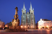 Noční fotografie chrudimského Resslova náměstí s barokní kašnou a Kostelem Nanebevzetí Panny Marie.
