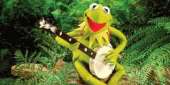 Loutka Jima Hensona žabák Kermit s banjem.