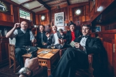 Skupina Vltava - fotografie u karetního stolu v podpalubí.