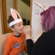 Slečna maluje dětem králičí fousky na obličej. 