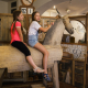 Dívky sedící na velkém dřevěném koni na výstavě Imaginárium.